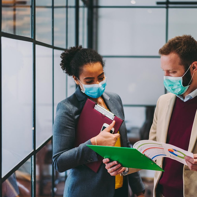 Business people wearing protective face masks at work during COVID-19 pandemic