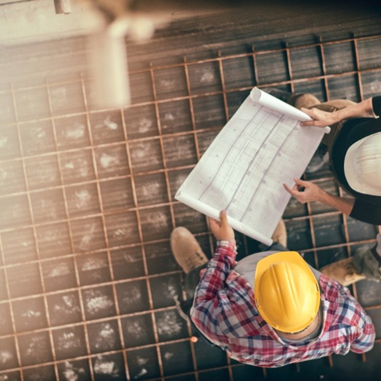 Female architect and two consruction workers on a construction site stock photo