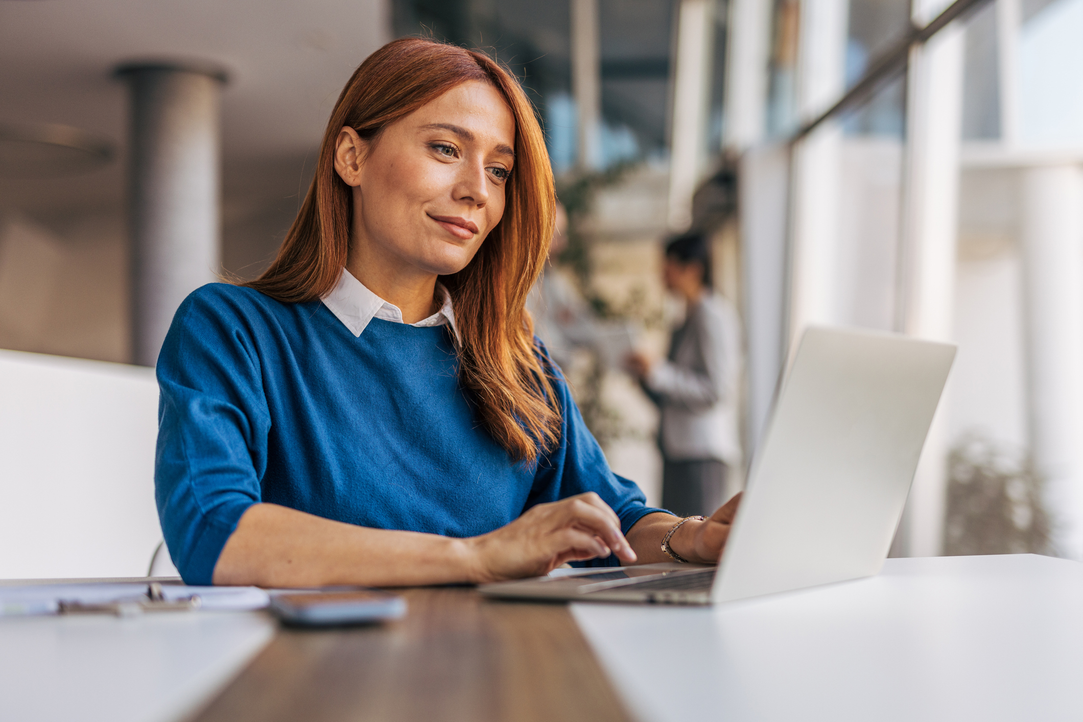 A successful businesswoman is using a laptop and working in the office